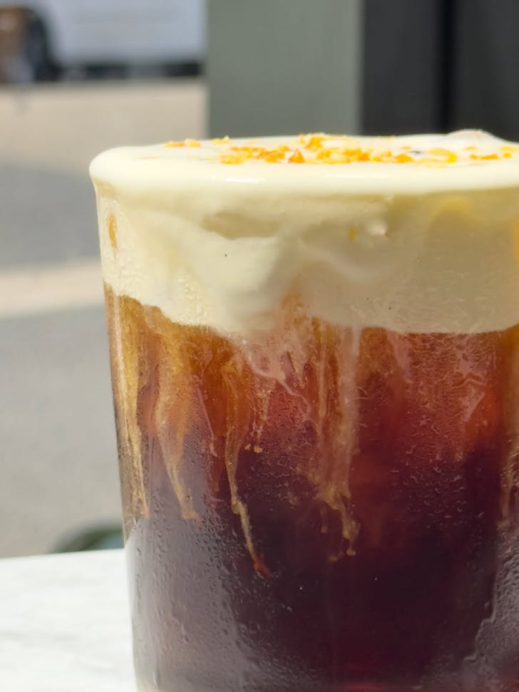 a glass of cold brew with cream on tip