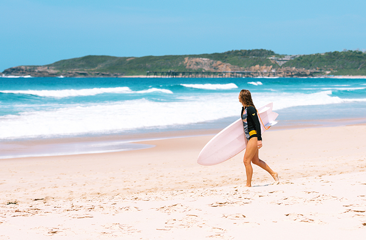 girl with surfboard on beach