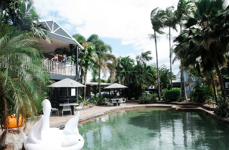 big queenslander style bulding with backyard pool and pool inflatables