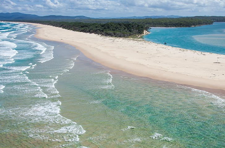 aerial view of pristine beach and rolling waves