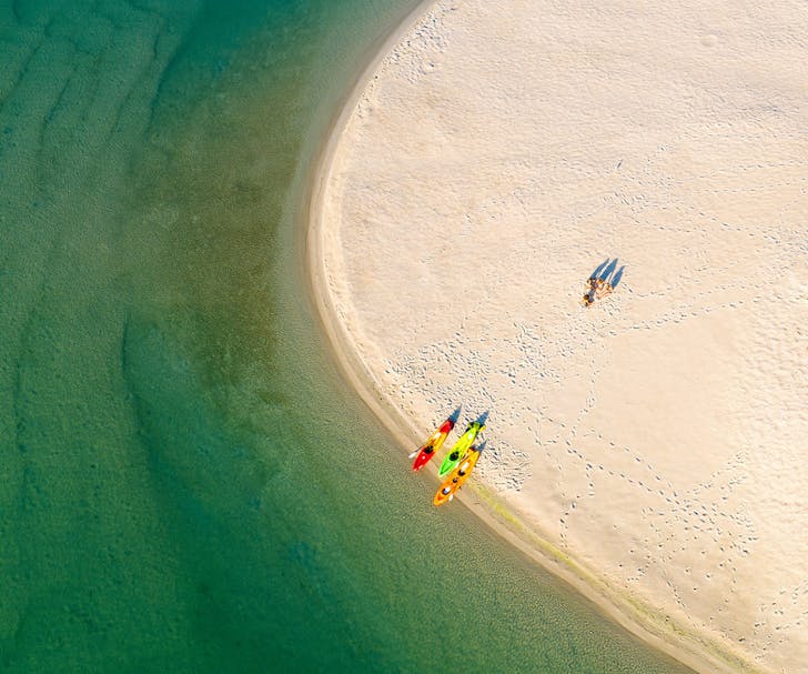 aerial view of two people with kayaks on sand bank