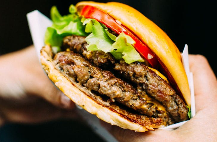 hands holding burgers