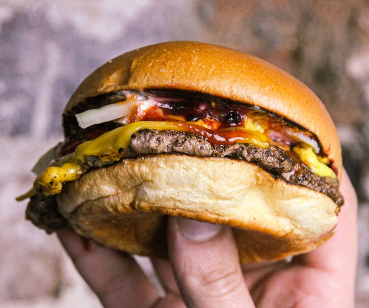 hand holding cheeseburger