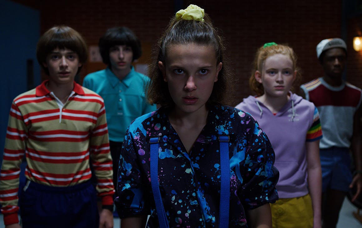 a group of teens gather in a group at night. 