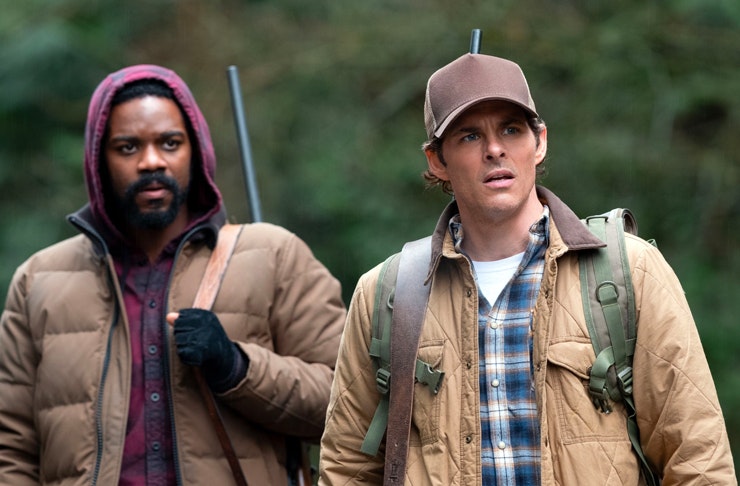 two men with backpacks in the forest