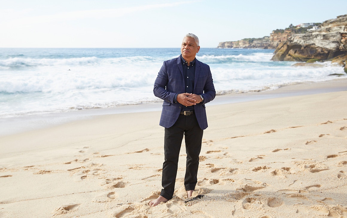 a man stands barefoot on the beach