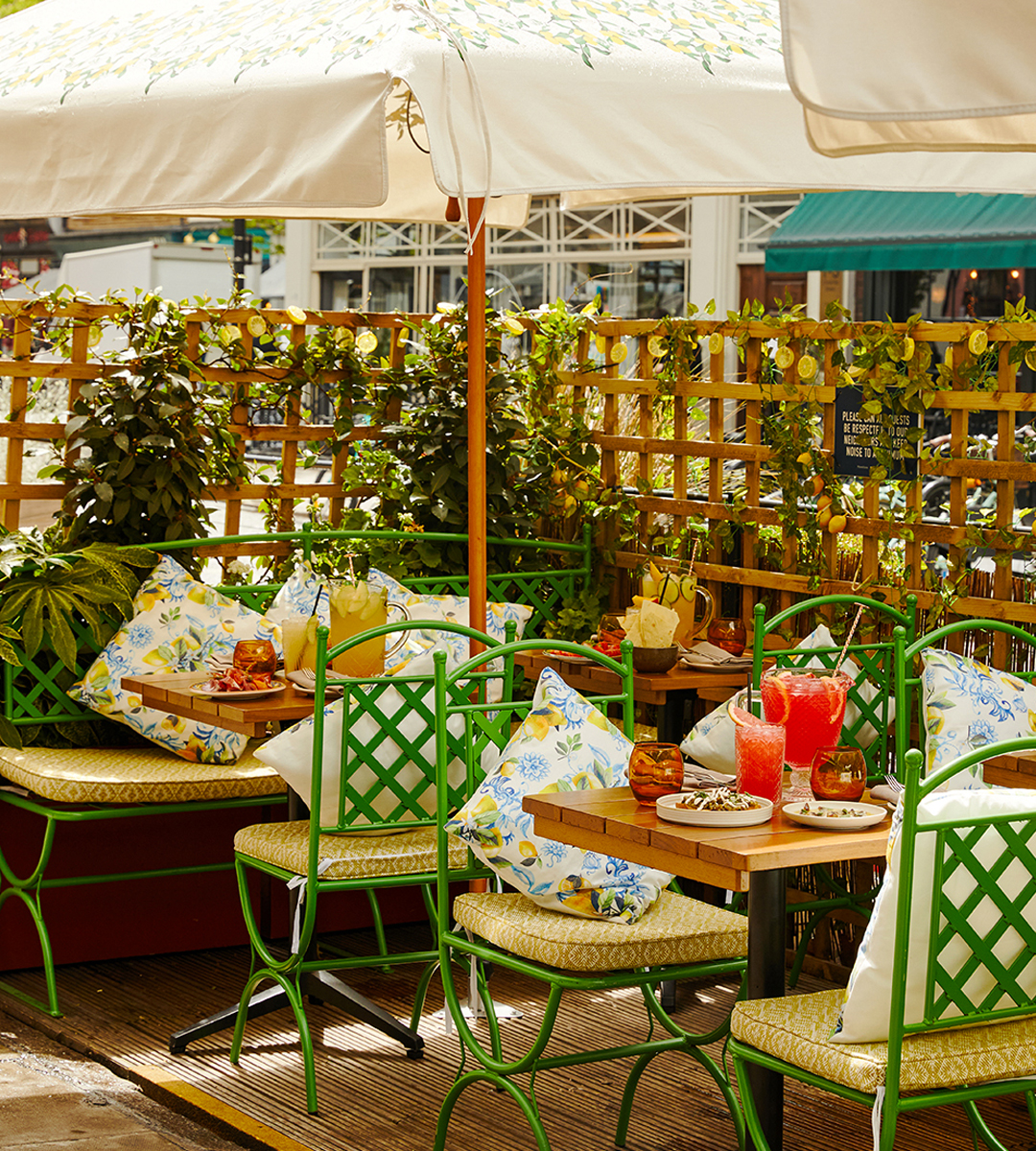 patio style tables and chairs under an umbrella