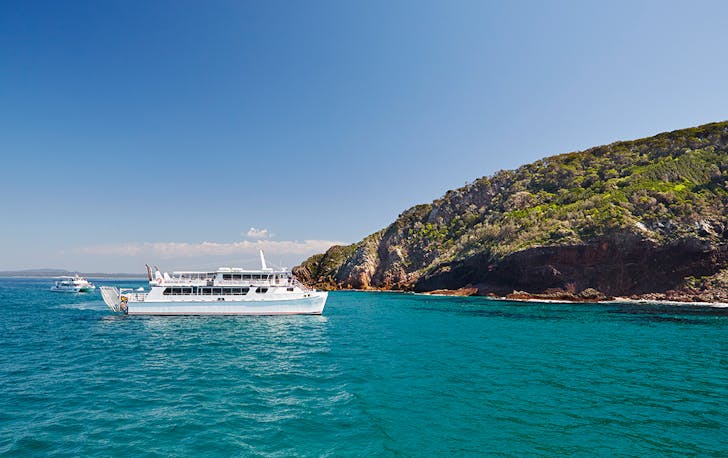 a boat pulls into the coastal town of Port Stephens