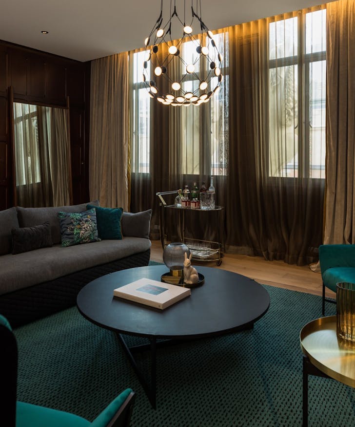 a moody suite at the QT sydney with grey couches and funky lighting