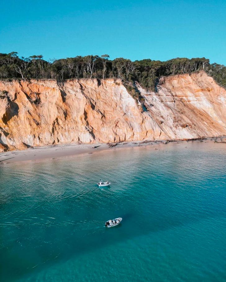 two boats on the water near coastline