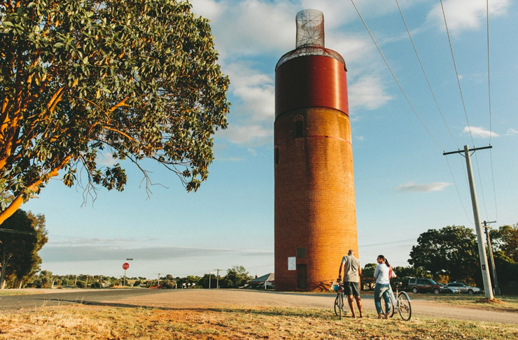 two people standing in front of rural tower on bike track