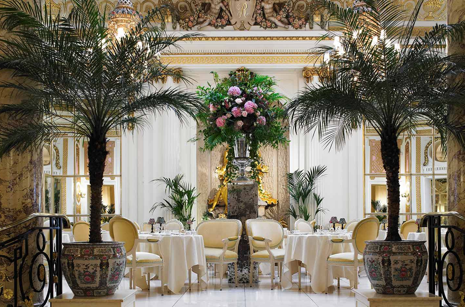 a marble foyer filled with tables and palms