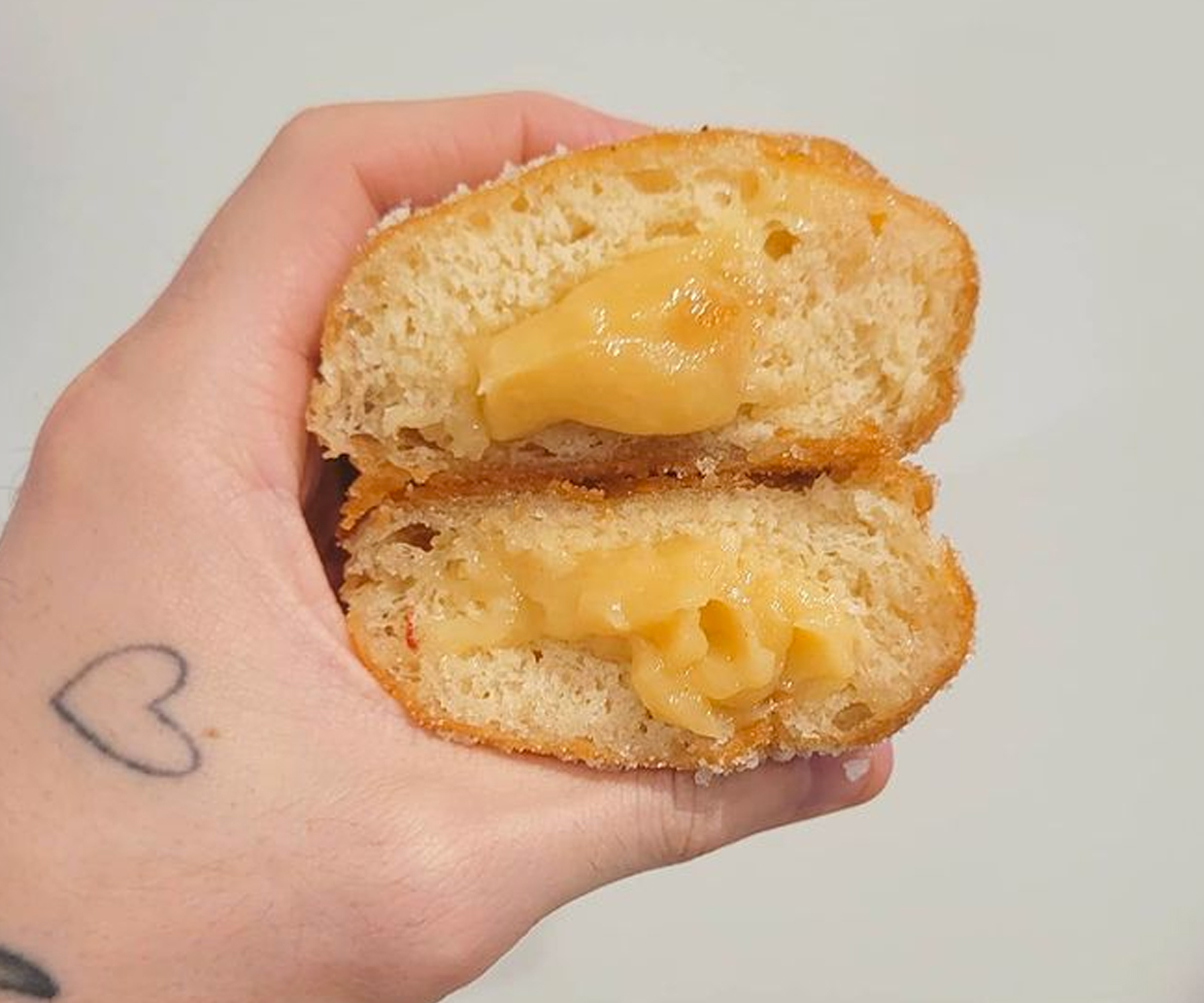 hand holding lemon filled doughnuts