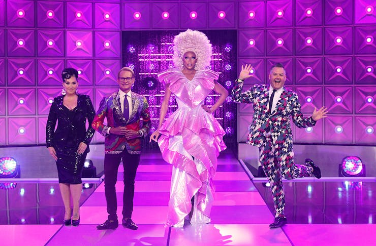 Rupaul and their fellow judges pose on a purple stage