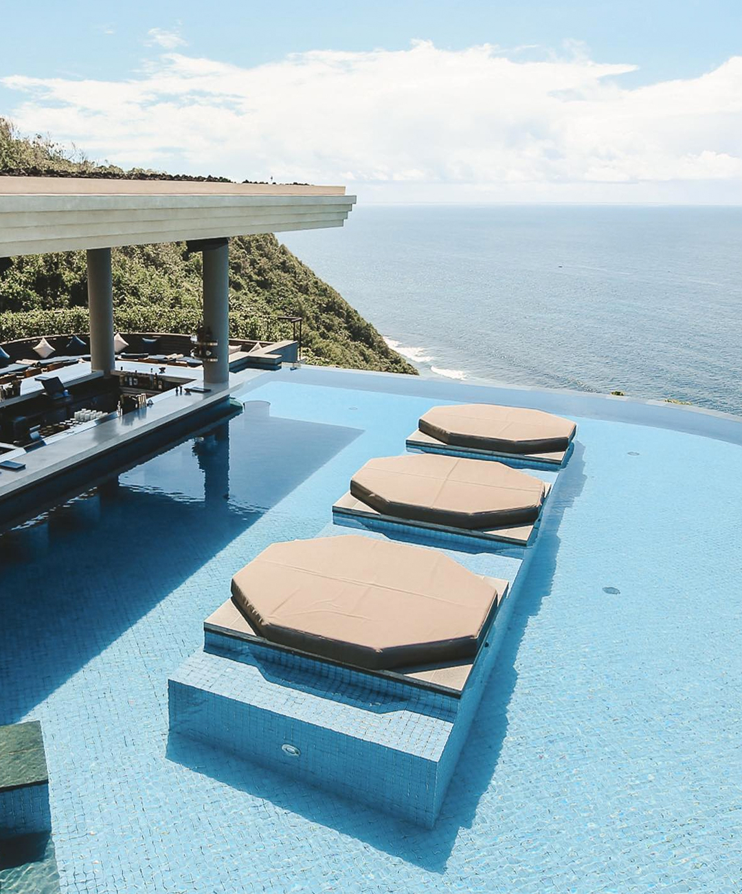 an infinity pool featuring a bar looking out over cliffs