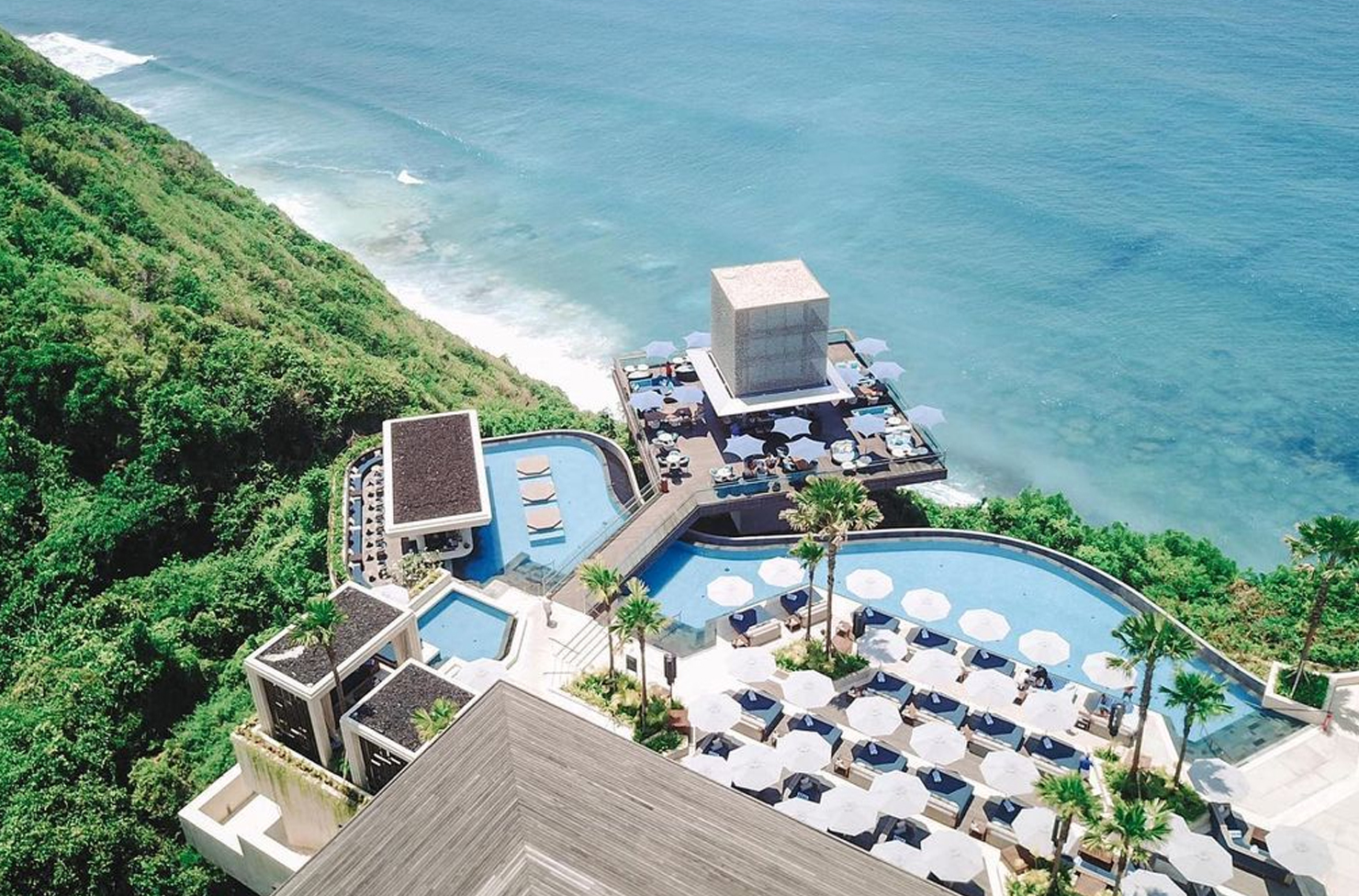 a hotel with an infinity pool overlooking cliffs