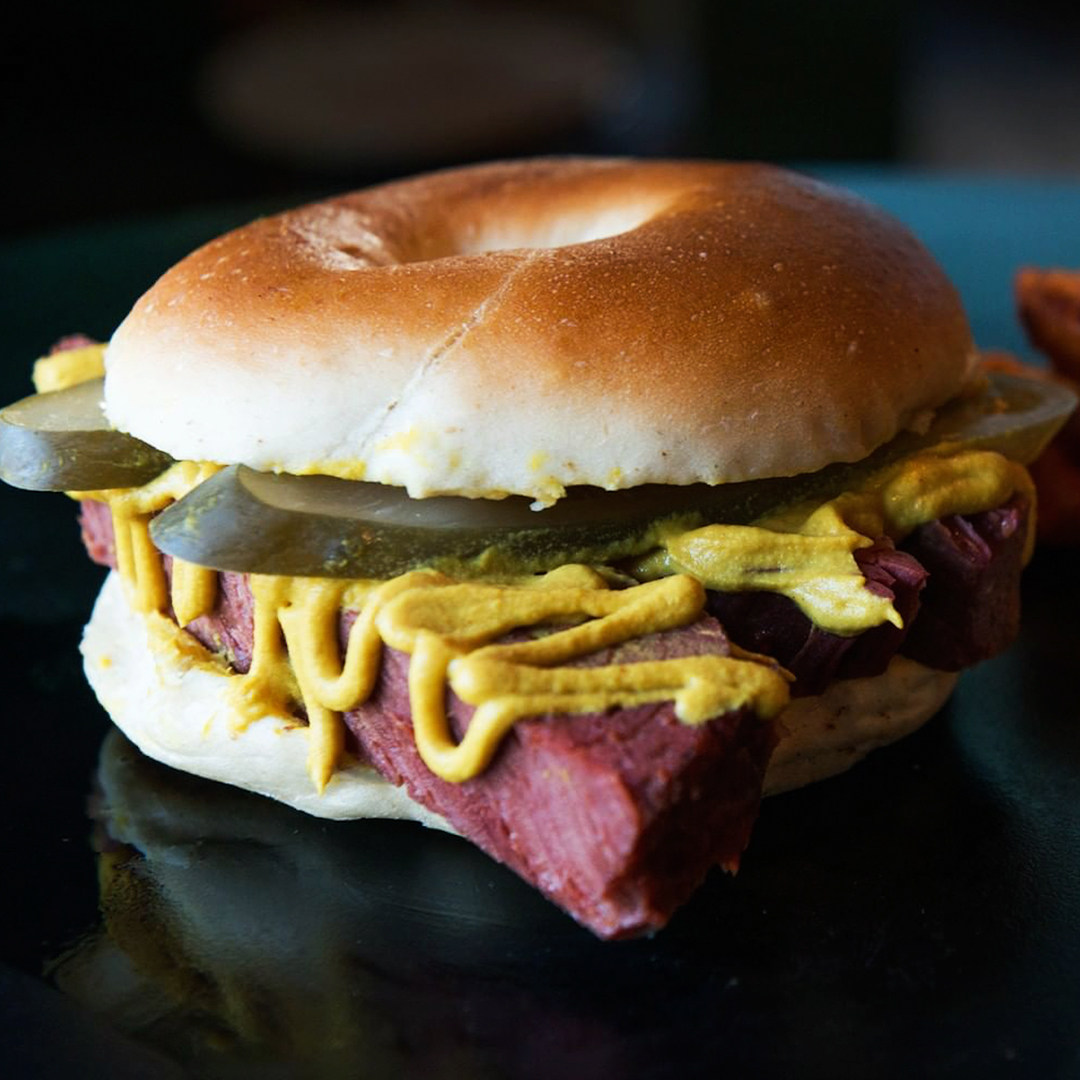 deliciously packed salt beef beigel loaded with pickles, mustard and smoked brisket