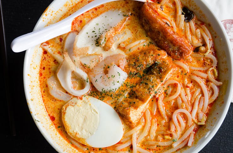 a drool-worthy bowl of laska in a white bowl.