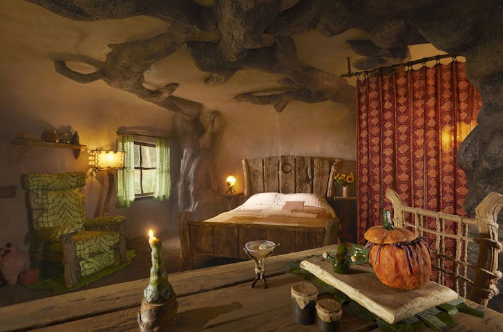 a bed and chairs inside a treehouse-looking stay