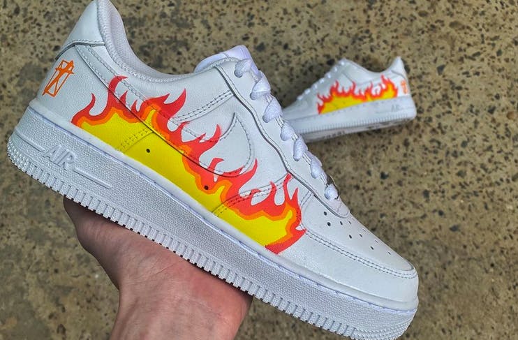 hand holding shoe with fire design