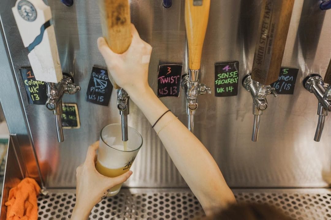 Hand pouring a beer from the tap. 