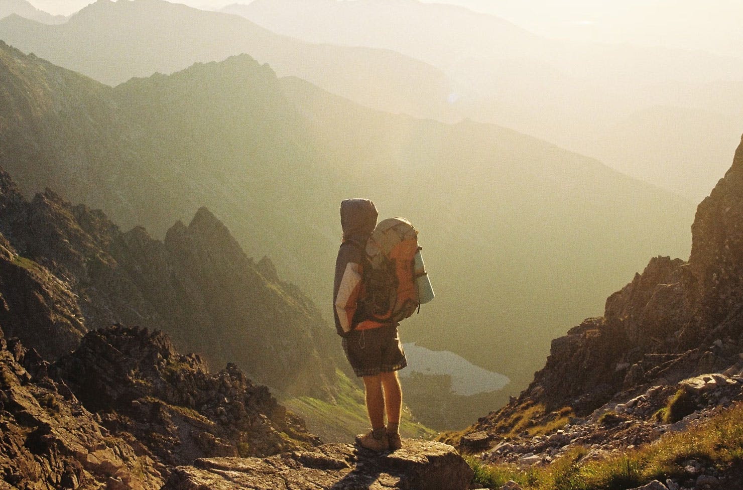 a backpacker standing on top of a mountain