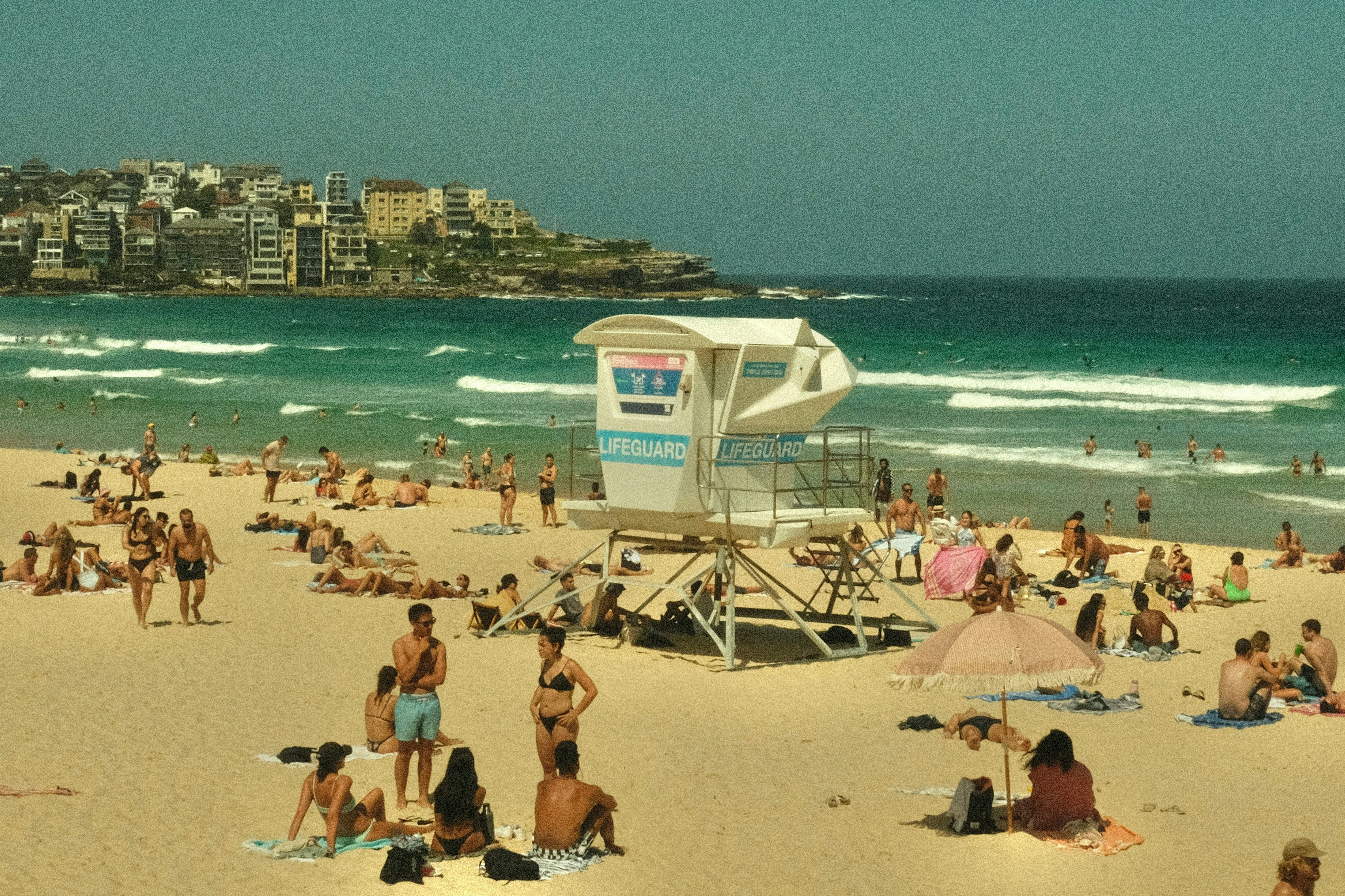 people sunbaking at the beach on a sunny day