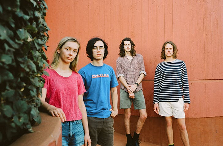 four people standing in alley way