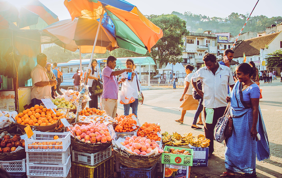 a group of Sri Lankan locals gather around a local market.
