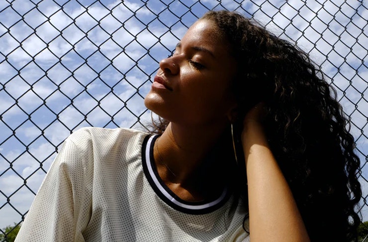 girl leaning on fence looking up at the sky