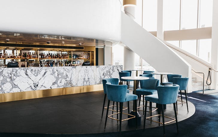 a curving white staircase leads to a marble fronted bar