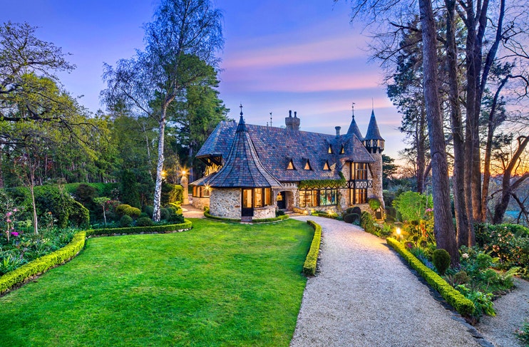 english style castle with huge front garden at sunset