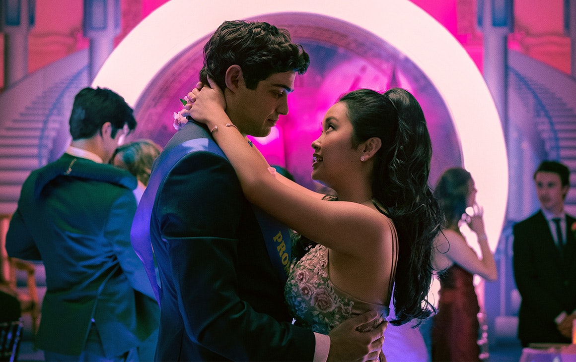 a young man and woman slow dance at a highschool prom