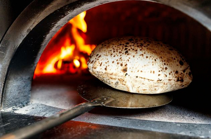 wood fired bread coming out of the oven