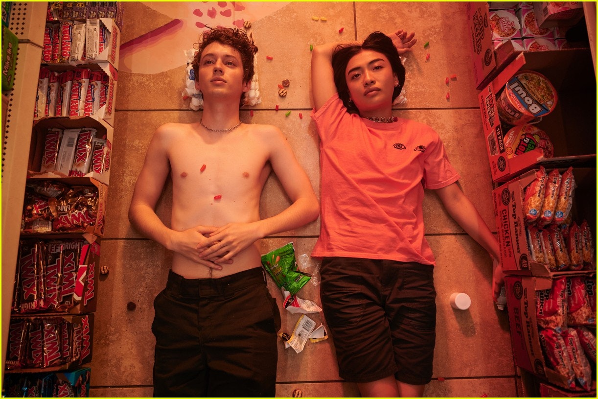 Two people laying on the ground covered in lollies in the film Three Months. 
