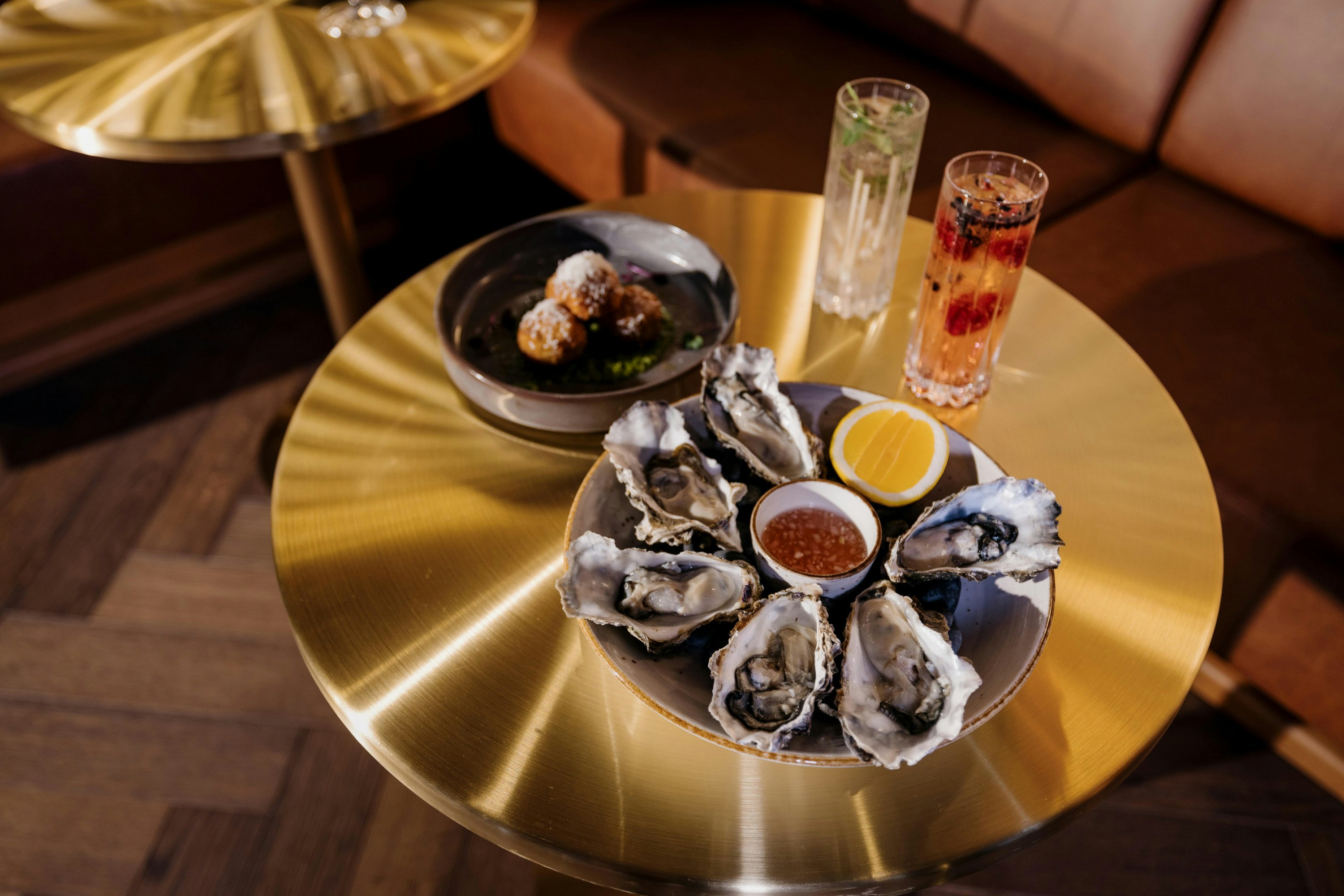 Tray of oysters on a brass table at Albert Bar; a rooftop bar at Vosco Auckland Hotel. 