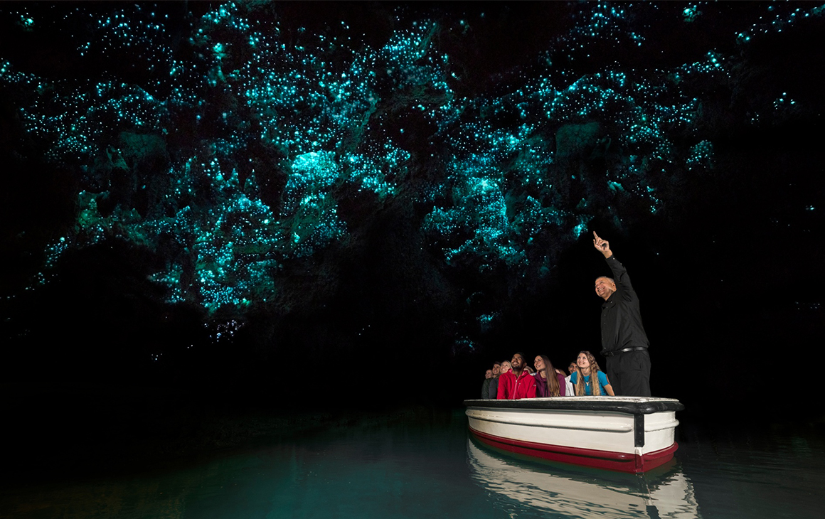a small boat floats under the Waitomo Glowworm Caves