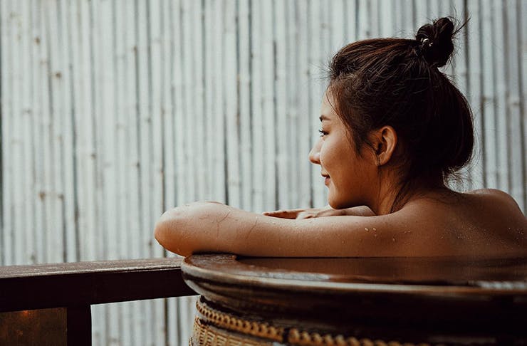 Woman sitting in an onsen looking out. 