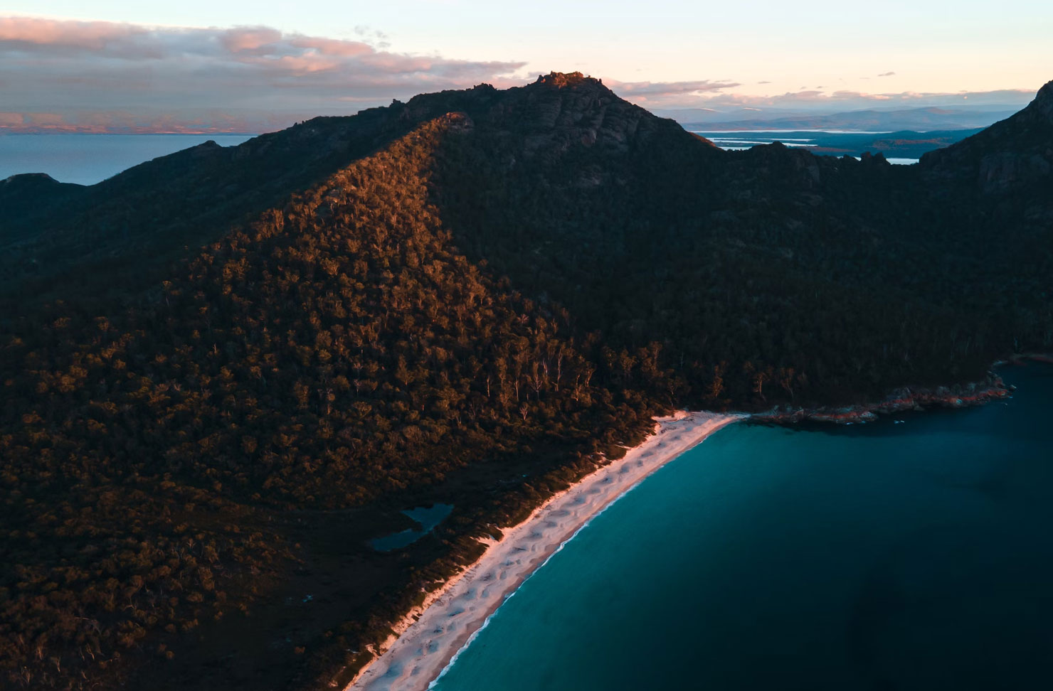 aerial of a coastal bay at sunset