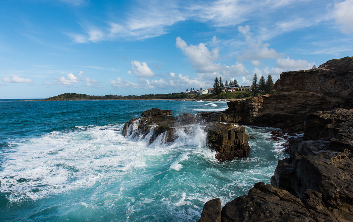 waves crash onto the cliffs at yamba