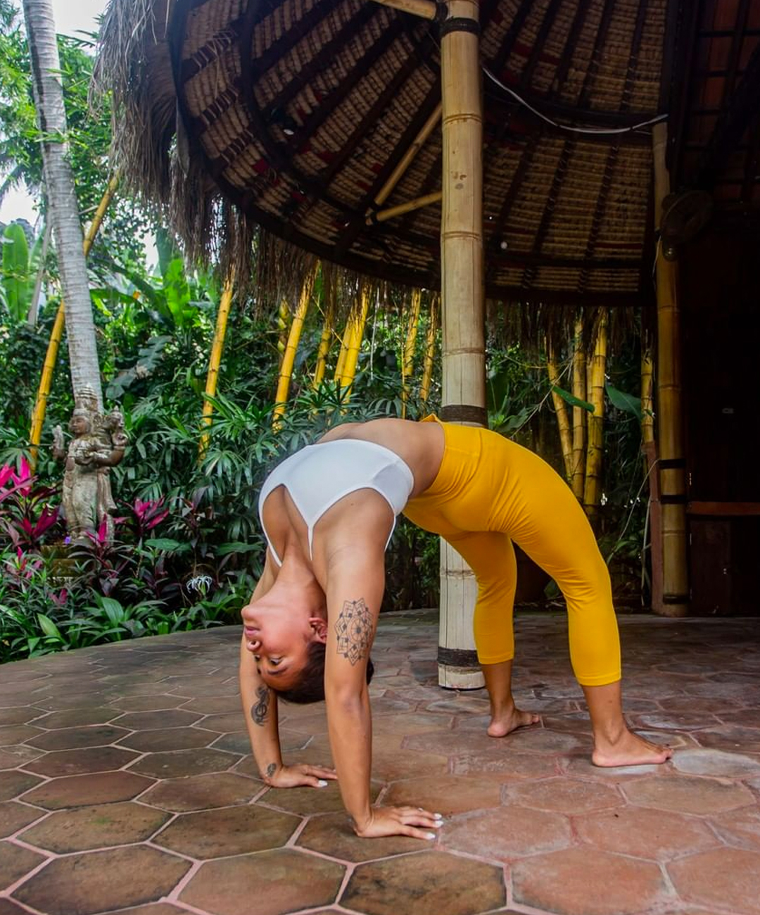 a person wearing yoga attire doing a backbend