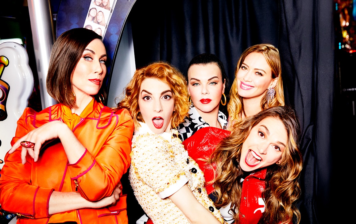 the cast of Younger cuddle up to each other in a photo booth, pulling funny faces