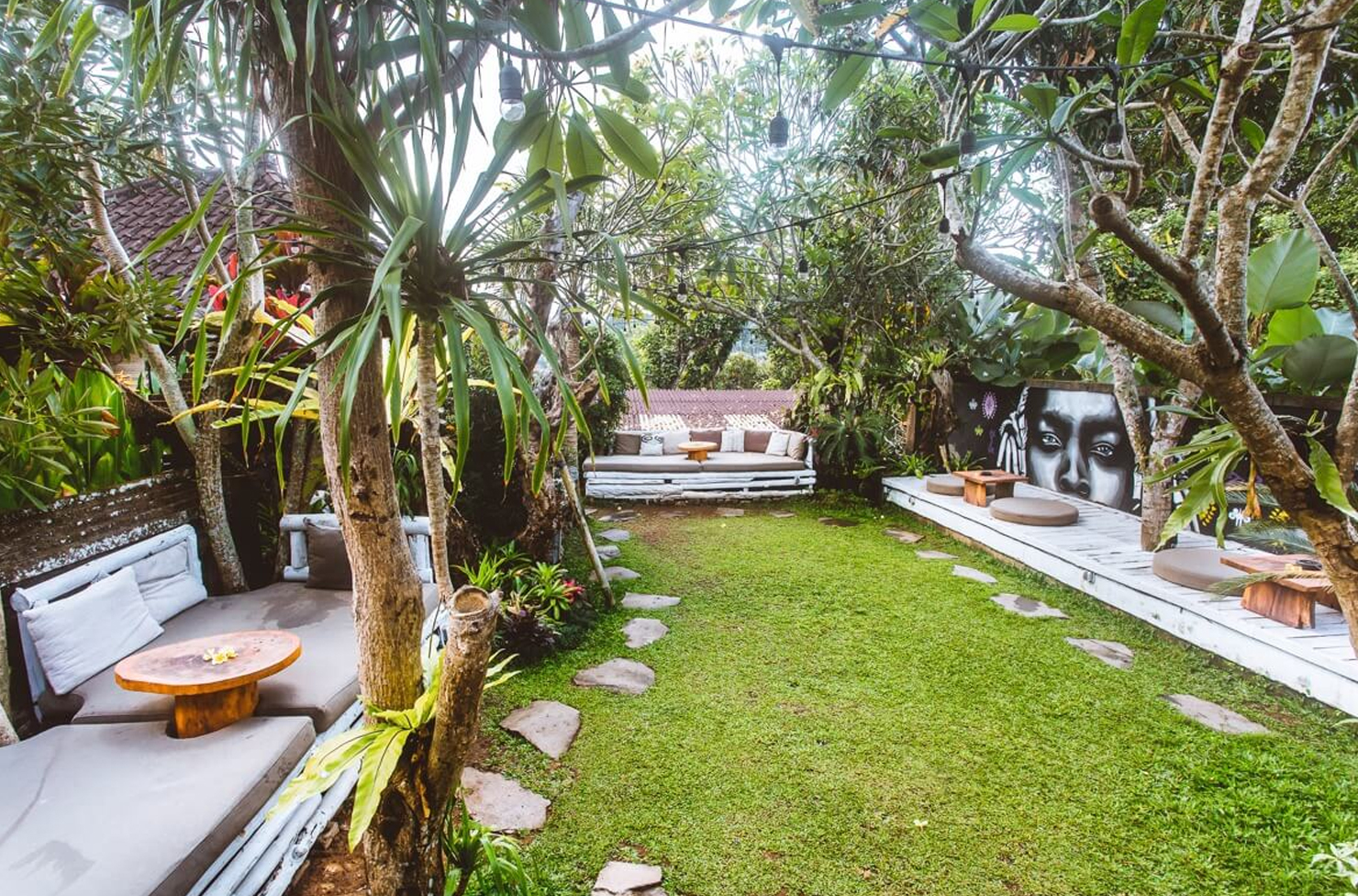 a backyard with palm trees and tables